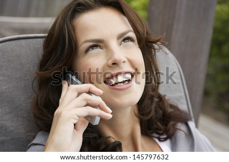 Closeup of beautiful young woman using cell phone on porch