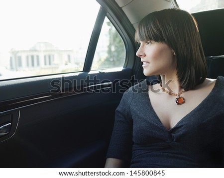 Young businesswoman at back seat of car looking out window