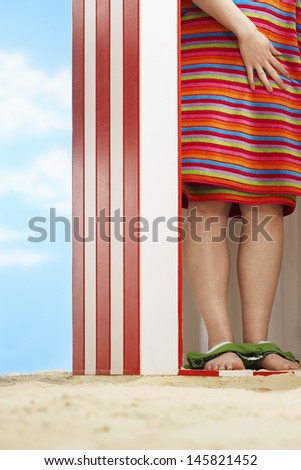 Low section of woman wrapped with towel in beach cabin