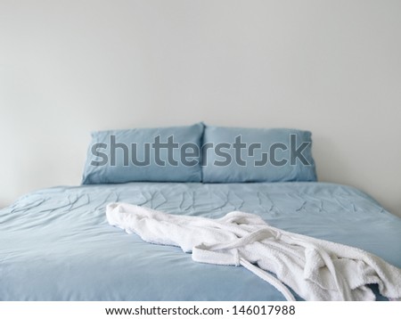 View Of A White Bathrobe On Blue Bed