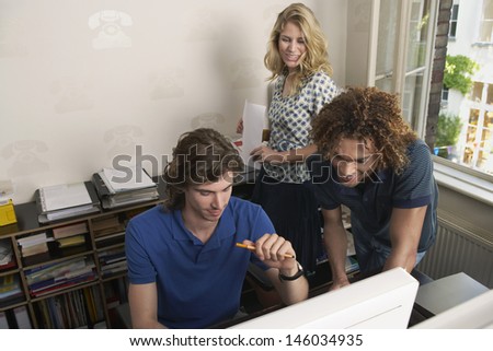 Young multiethnic business people looking at computer in the office