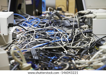 Closeup Of Messed Wires Connecting Computers And Printers In Office