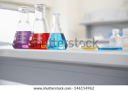Closeup of beakers of multicolored liquid in laboratory