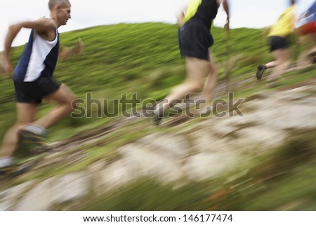 Side view of blurred group of people running on track