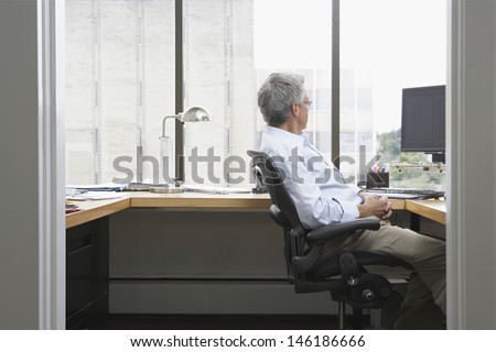 Side view of a businessman sitting at desk in office