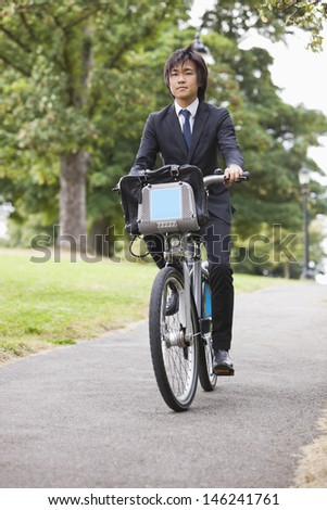 Portrait of young businessman commuting by his bicycle