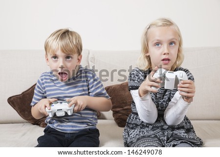 Young brother and sister playing video game