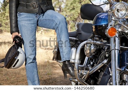 Womans leg rests on motorcycle foot rest