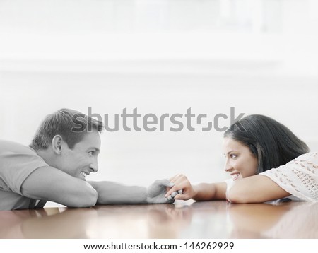 Affectionate young couple holding hands across table