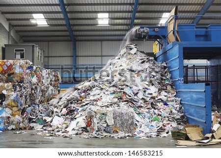 Waste falling on pile from conveyor belt at recycling factory Waste falling on pile from conveyor belt at recycling factory