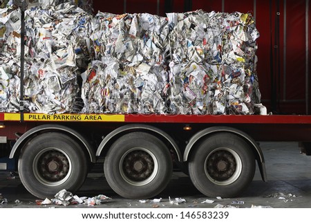Stacks of recycled papers on lorry in recycling plant