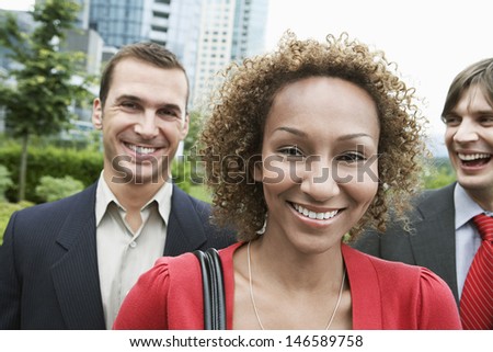 Closeup portrait of a smiling African American woman with male colleagues