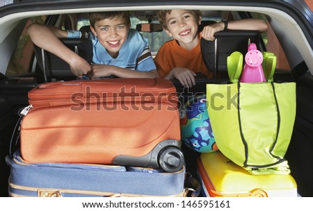 Portrait of smiling young boys in loaded car