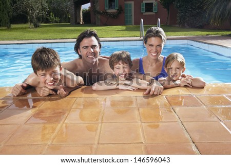 Portrait of a happy couple with three children in swimming pool