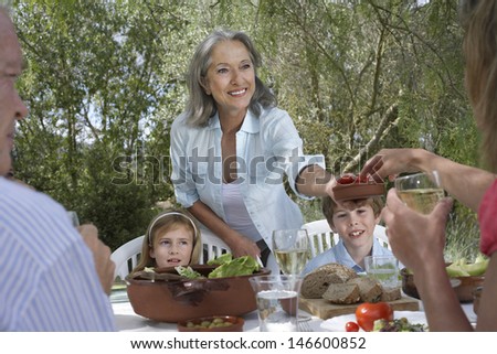 Three generation family eating at garden table