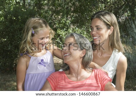 Portrait of smiling grandmother; mother and daughter in the garden