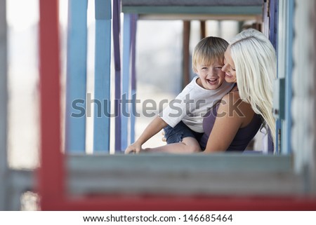 Cheerful mother and son playing at porch