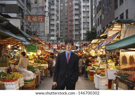 Portrait of happy young businessman at street market