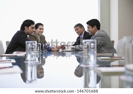Four Indian Business People Discussing At Conference Table