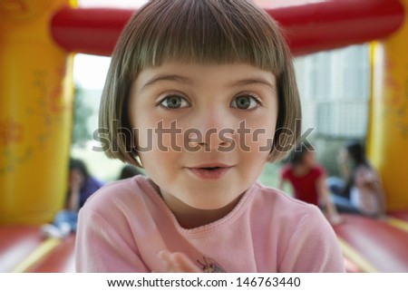 Closeup portrait of cute little girl in jumping castle