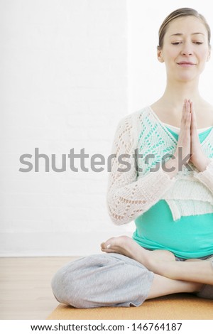 Woman sitting cross legged in a yoga pose at gym
