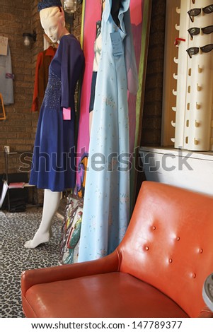 View of clothing and furniture in a crowded second hand store