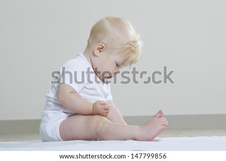 Full length side view of a baby girl playing on floor