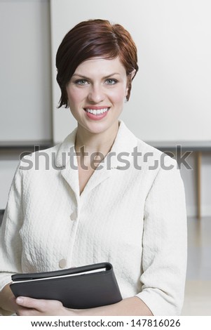 Portrait of a smiling Caucasian businesswoman holding folder