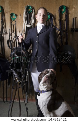 Portrait of a confident female horseback rider with dog