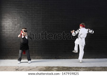 Full length of two dressed up boys pretending to fight