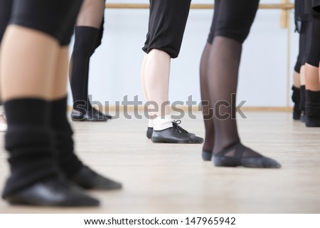 Low section of young ballet dancers practicing in rehearsal room