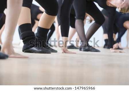 Low section of ballet dancers practicing in rehearsal room