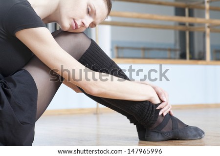 Beautiful young woman resting in ballet rehearsal room