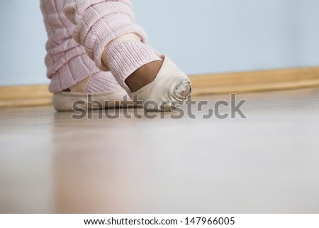 Low section of feet of female ballerina in rehearsal room