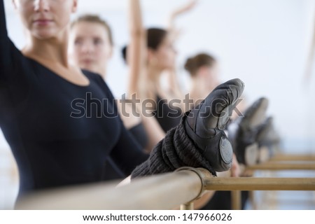 Row Of Ballet Dancers Practicing At The Barre In Rehearsal Room