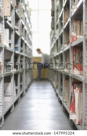 Aisles in university library with shelves full of colour coded filing