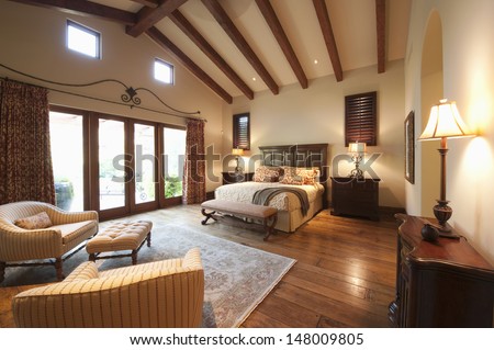 Spacious bedroom with beamed wooden ceiling