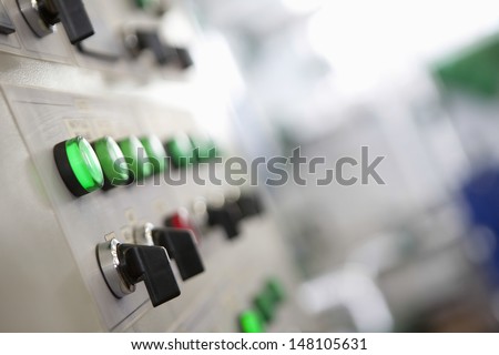 Closeup Of Lit Lights And Control Dials On Manufacturing Machinery