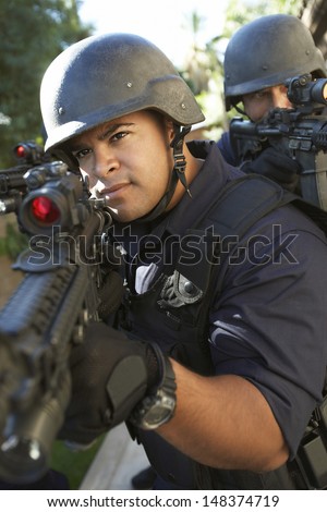 Police officers aiming with guns