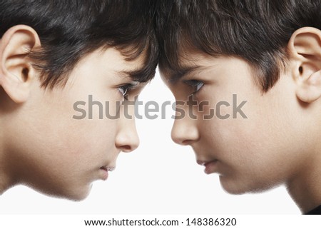 Closeup of preadolescent siblings with head to head isolated over white background