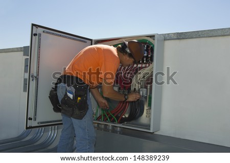 Engineer working on electrical box at solar power plant