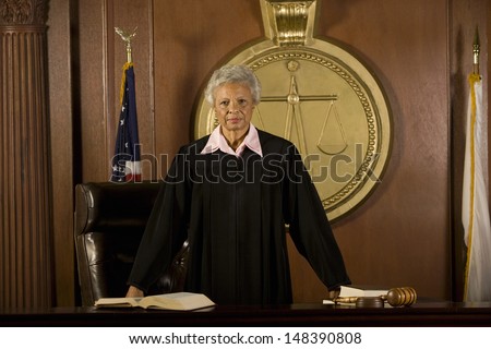 Portrait of confident senior female judge standing in court room