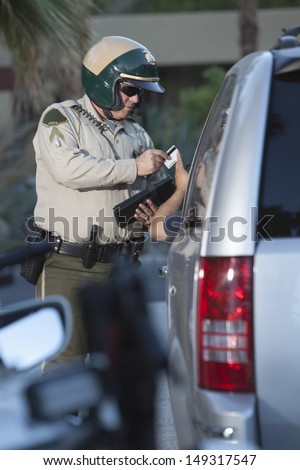 Middle aged traffic cop receiving credit card from driver