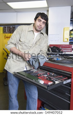 Portrait of a young man in workshop with tools