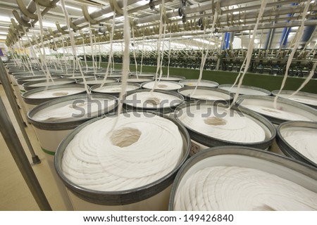 Rolls of fabric and machinery in spinning factory