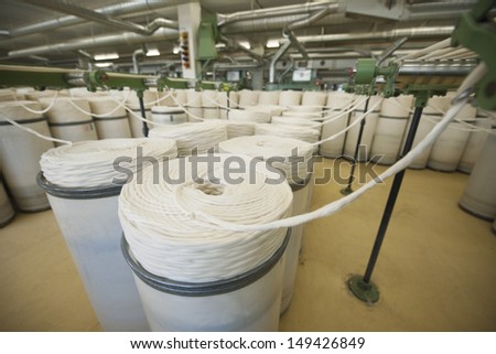 Rolls of fabric and machinery in spinning factory