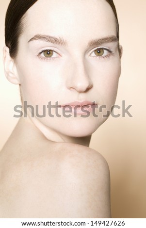 Closeup portrait of a young woman with fresh skin against colored background