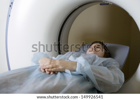 Young woman lying in front of CAT scan machine