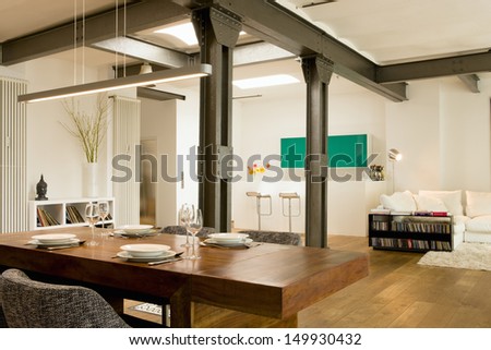 Dining room with view of bar and living area in the background at modern home