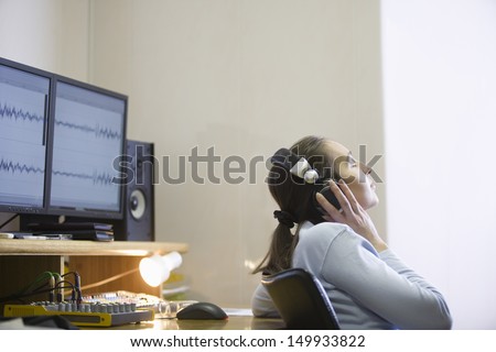 Side view of a female sound engineer listening to music